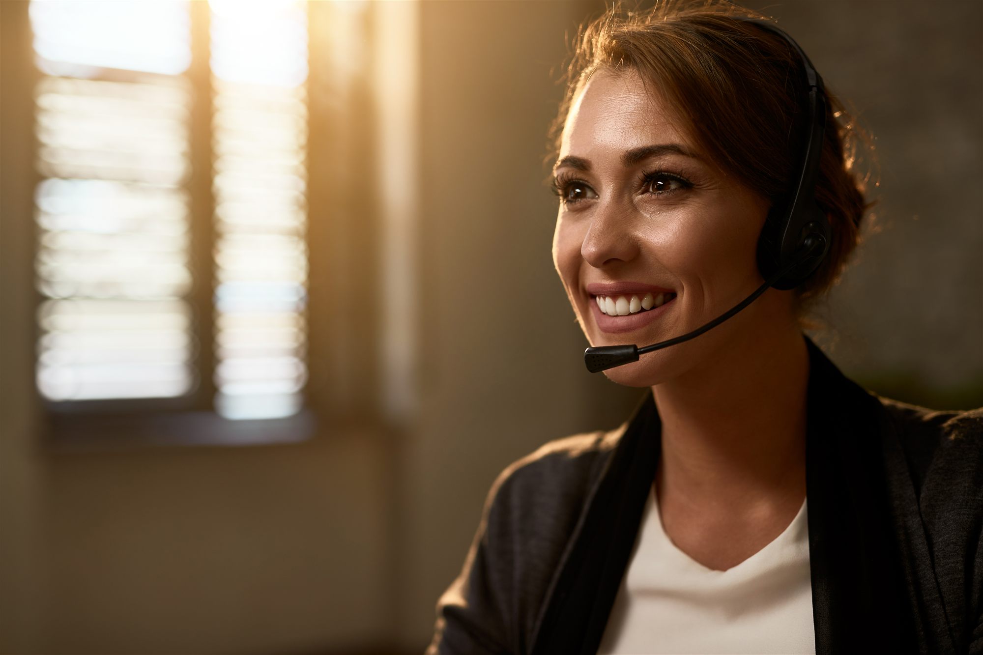 Asesora sonriente con diadema en el contact center
